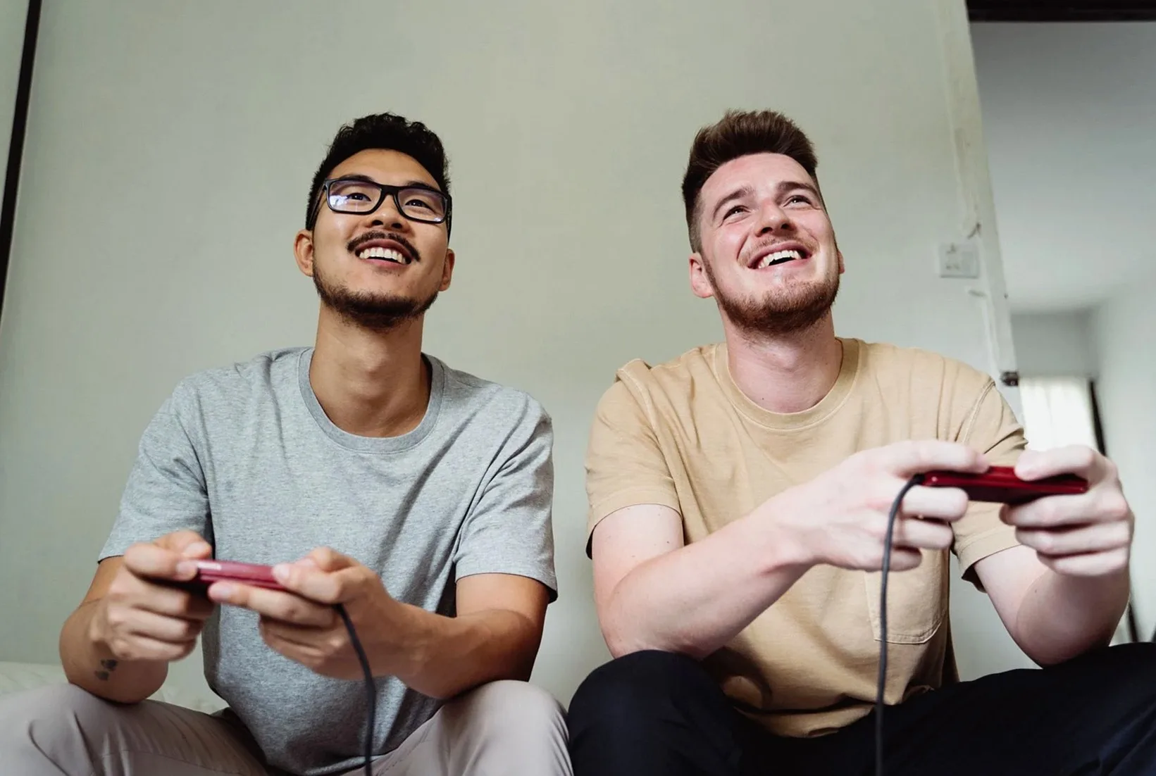コントローラーを手にゲームを楽しむ二人の男性